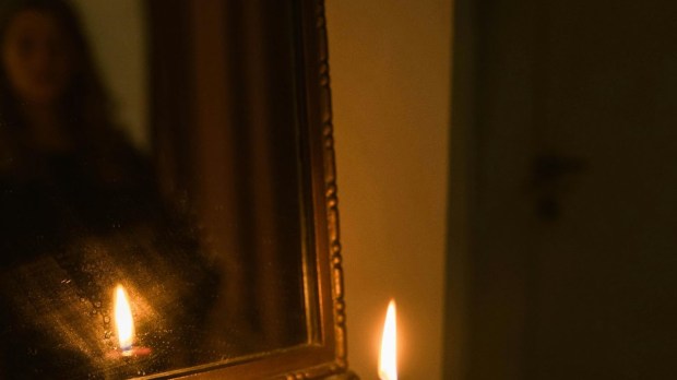 bright white flame in a dark mirror