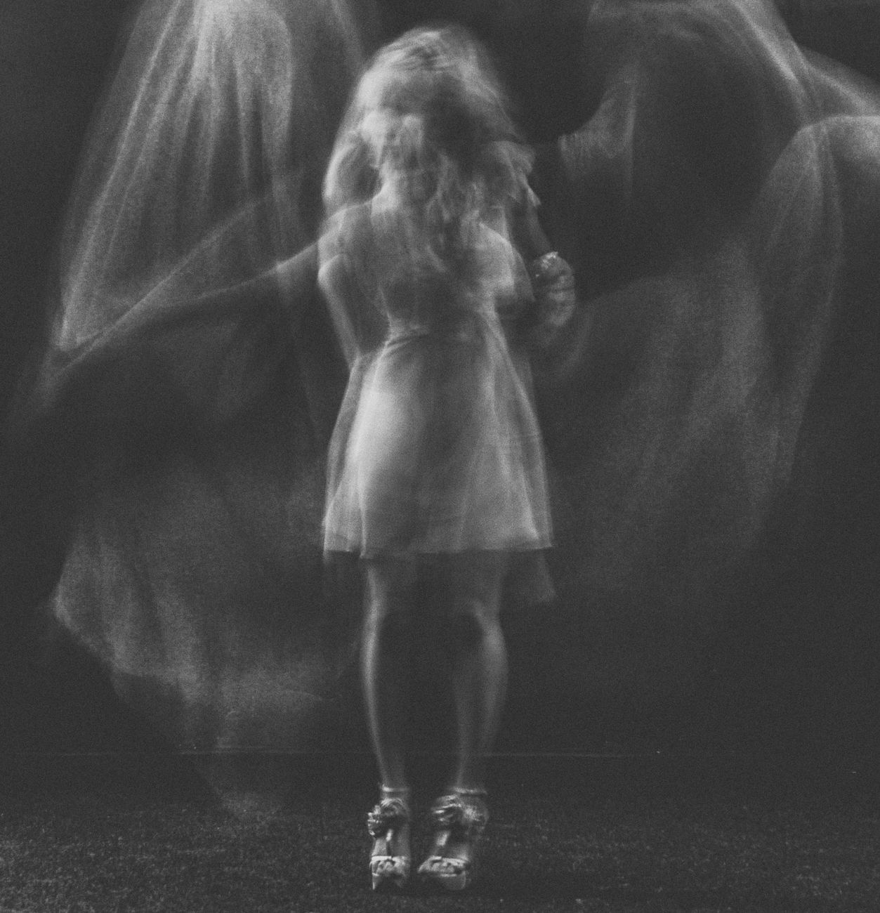 black and white photo evoking a female apparition, possibly with angel's wings, but not an ange.